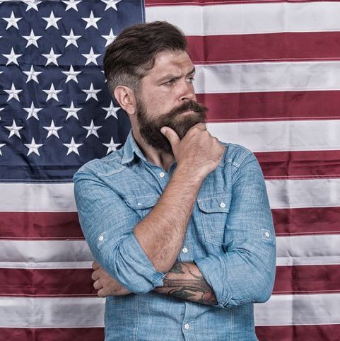 man looking worried in front of American flag