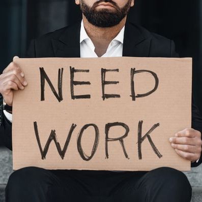 man holding sign that says need work